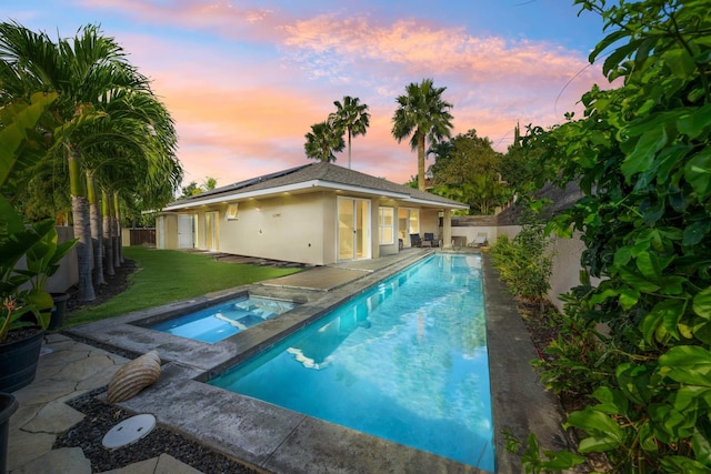 view of pool with a yard, an in ground hot tub, a fenced backyard, and a patio area