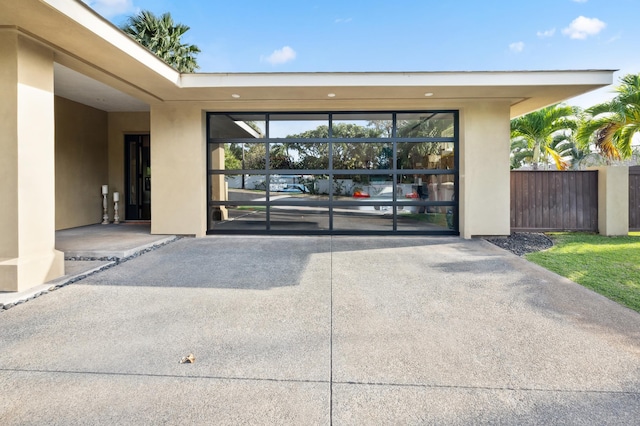 property entrance featuring stucco siding and fence