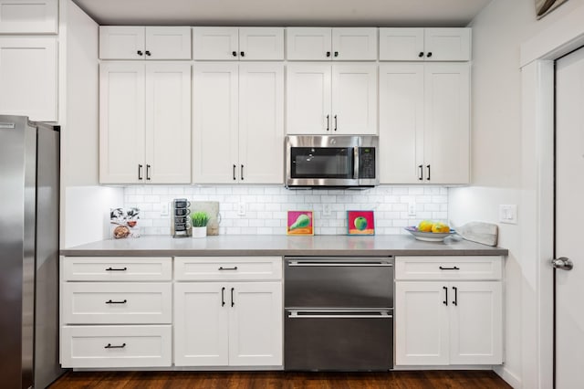 kitchen with tasteful backsplash, white cabinets, and stainless steel appliances