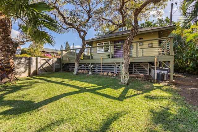 rear view of house featuring a lawn and a deck