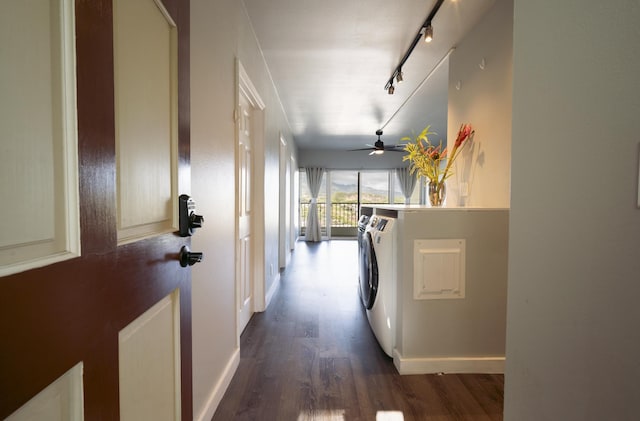 hallway with dark hardwood / wood-style flooring, washer and dryer, and rail lighting