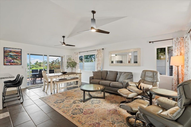 living area featuring baseboards, a ceiling fan, and vaulted ceiling