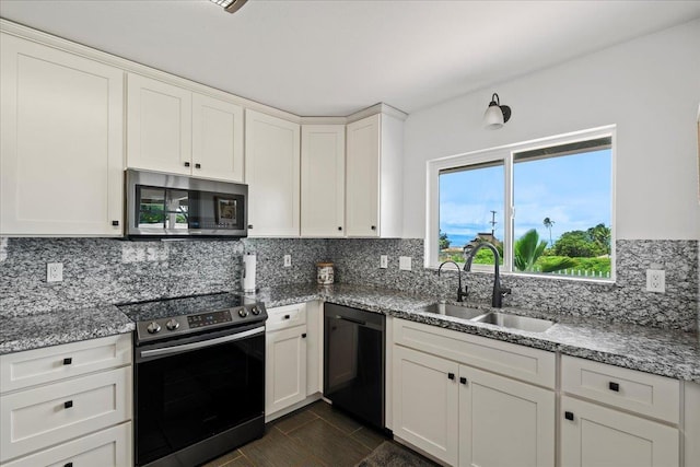 kitchen featuring white cabinets, light stone counters, a sink, stainless steel appliances, and backsplash