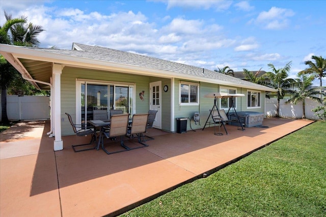 back of house featuring a patio, fence, and a shingled roof