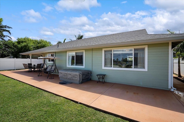 rear view of property with roof with shingles, a patio area, and fence