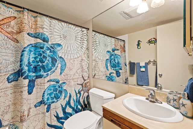 bathroom with a textured ceiling, toilet, and vanity