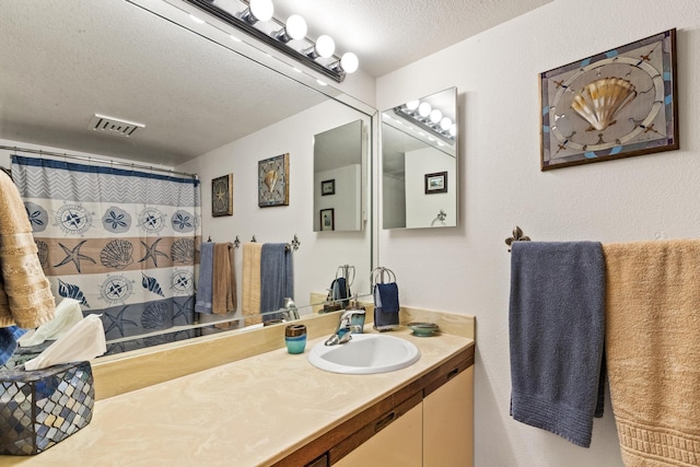 bathroom featuring a textured ceiling, visible vents, vanity, and a shower with curtain