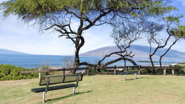 view of community with a lawn and a water and mountain view