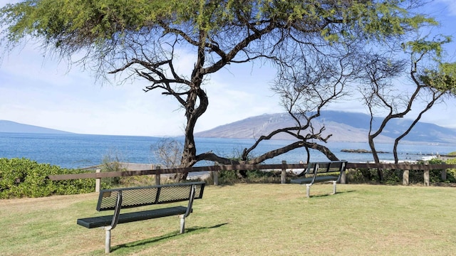 surrounding community featuring a water and mountain view and a yard