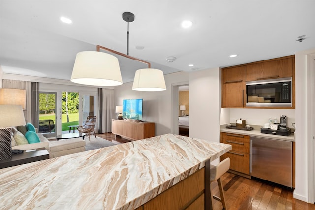 kitchen featuring decorative light fixtures, black microwave, dark hardwood / wood-style floors, and stainless steel dishwasher