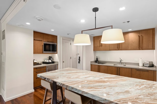 kitchen featuring hanging light fixtures, sink, built in microwave, and dark hardwood / wood-style flooring