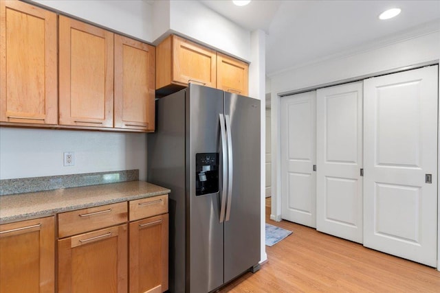 kitchen featuring stainless steel refrigerator with ice dispenser, ornamental molding, and light hardwood / wood-style floors