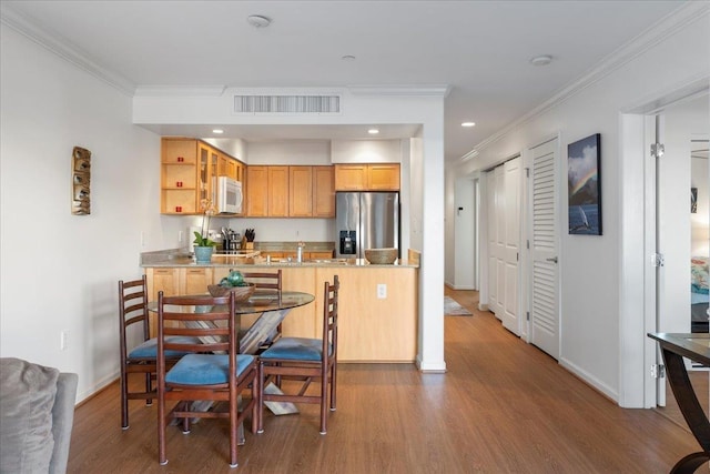 kitchen with sink, stainless steel fridge, dark hardwood / wood-style flooring, ornamental molding, and kitchen peninsula