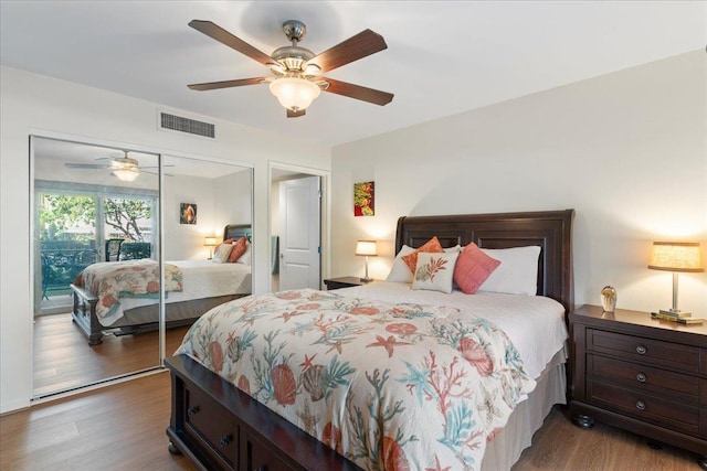 bedroom with dark hardwood / wood-style flooring, ceiling fan, and a closet