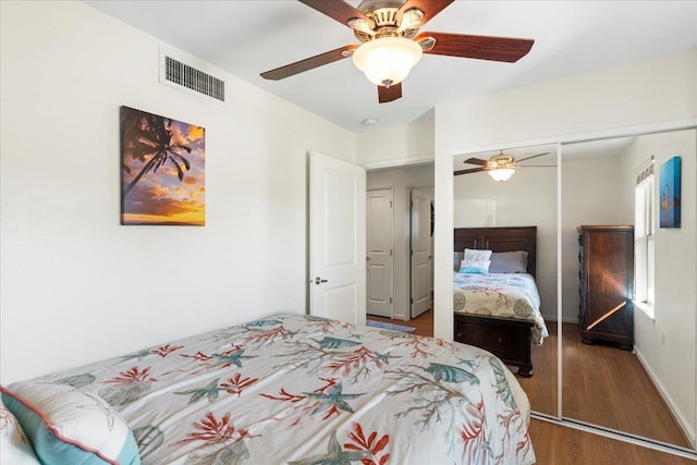 bedroom with ceiling fan, dark hardwood / wood-style flooring, and a closet