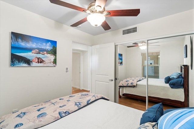 bedroom with hardwood / wood-style flooring, a closet, and ceiling fan