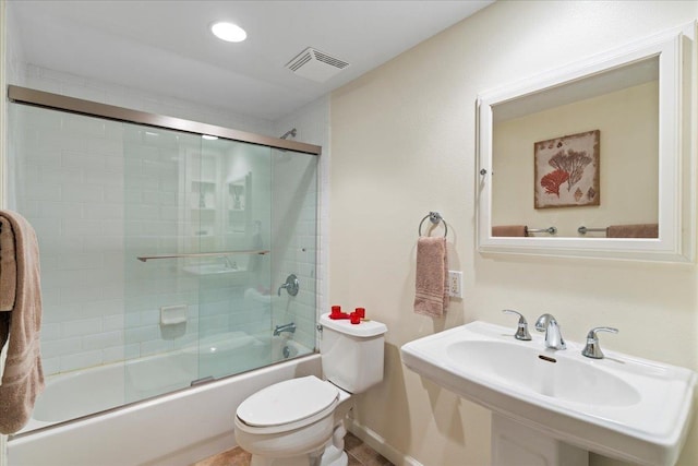 full bathroom featuring sink, tile patterned floors, shower / bath combination with glass door, and toilet