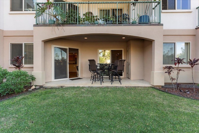 back of house featuring a balcony, a lawn, and a patio area