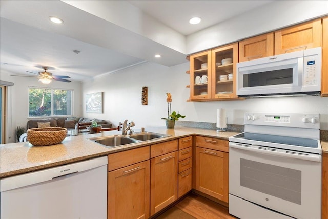 kitchen featuring sink, white appliances, kitchen peninsula, and light wood-type flooring