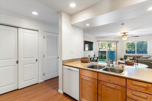 kitchen featuring crown molding, dishwasher, sink, and light hardwood / wood-style flooring