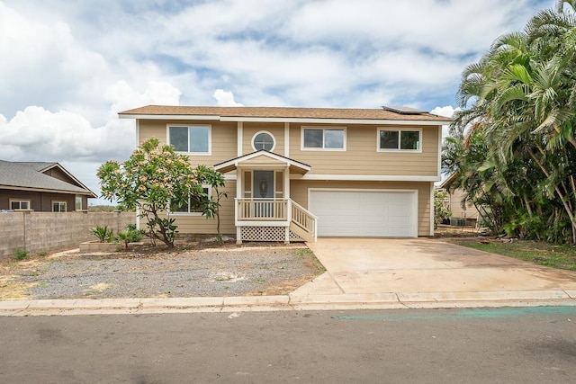 495 Kaiolohia St, Kihei, HI 96753 - view of front facade with fence, concrete driveway, solar panels, and a garage