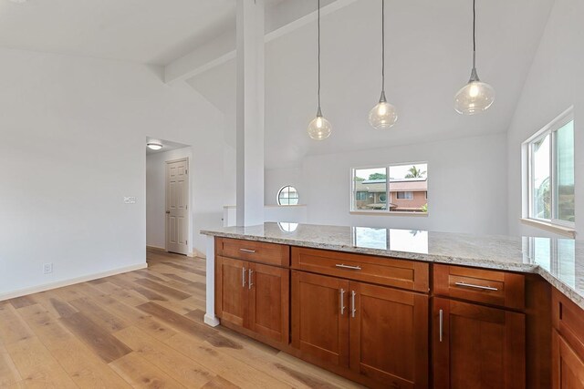 495 Kaiolohia St, Kihei, HI 96753 - kitchen featuring light wood-style floors, light stone countertops, beamed ceiling, and brown cabinetry
