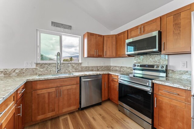 495 Kaiolohia St, Kihei, HI 96753 - kitchen featuring lofted ceiling, brown cabinets, light wood-style flooring, a sink, and appliances with stainless steel finishes