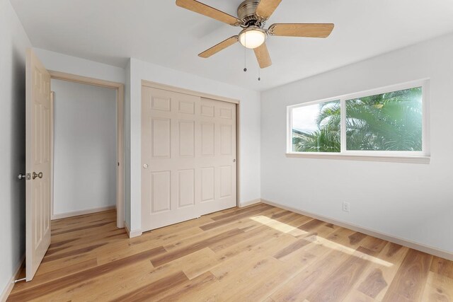 495 Kaiolohia St, Kihei, HI 96753 - unfurnished bedroom with baseboards, light wood-type flooring, ceiling fan, and a closet