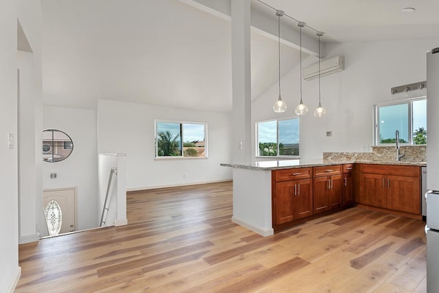 495 Kaiolohia St, Kihei, HI 96753 - kitchen featuring light stone countertops, a peninsula, a wall mounted air conditioner, high vaulted ceiling, and brown cabinetry