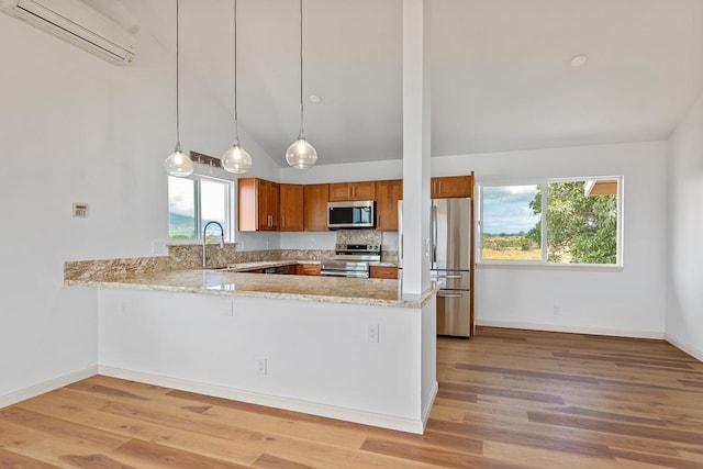 495 Kaiolohia St, Kihei, HI 96753 - kitchen featuring brown cabinetry, stainless steel appliances, light wood-style floors, a wall mounted air conditioner, and a peninsula