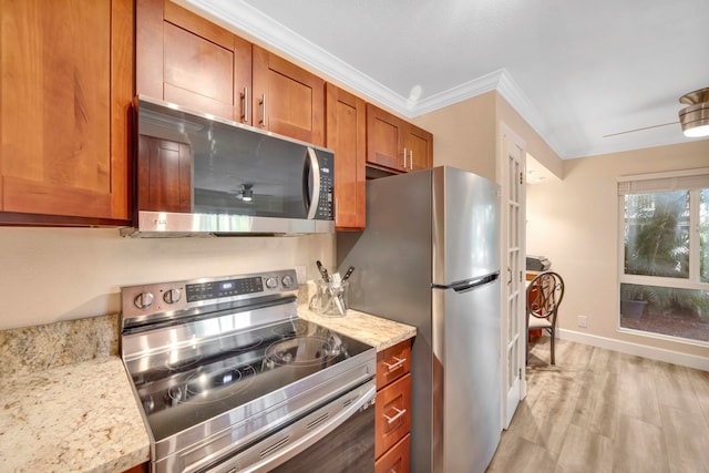 kitchen featuring crown molding, appliances with stainless steel finishes, light wood-type flooring, ceiling fan, and light stone counters