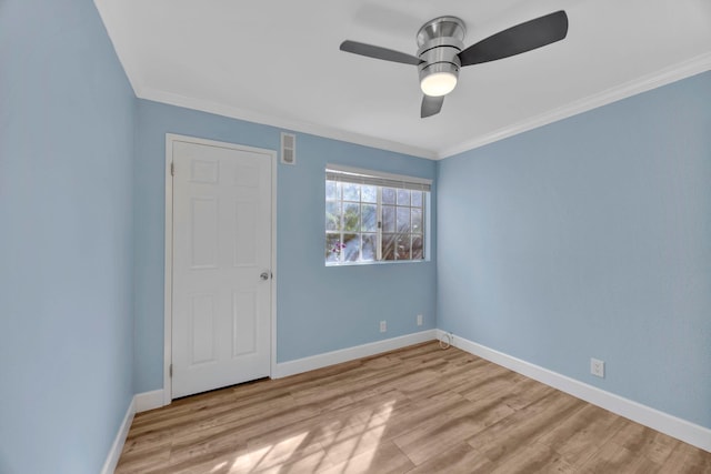 empty room with crown molding, light hardwood / wood-style floors, and ceiling fan