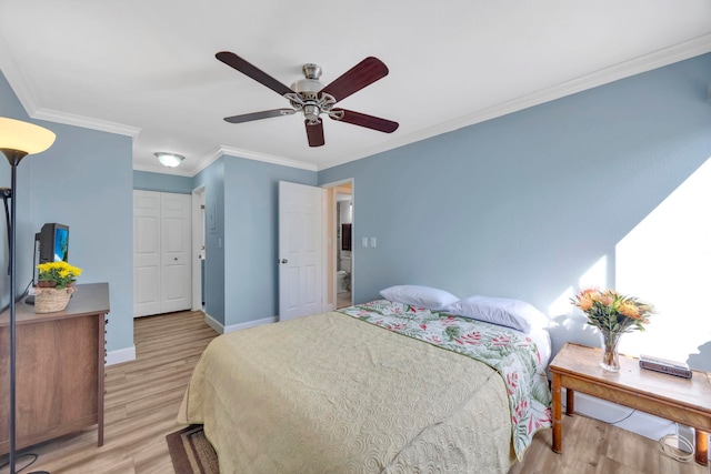 bedroom featuring ceiling fan, a closet, light hardwood / wood-style flooring, and crown molding