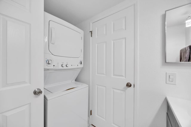 clothes washing area featuring stacked washer and dryer