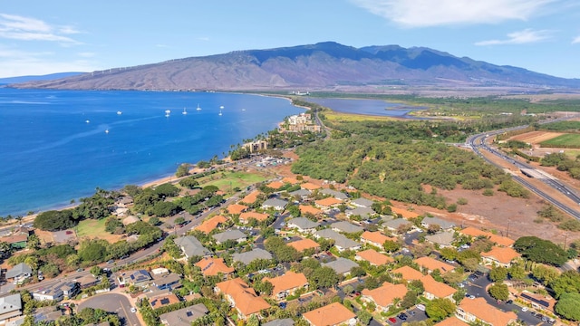 drone / aerial view featuring a water and mountain view