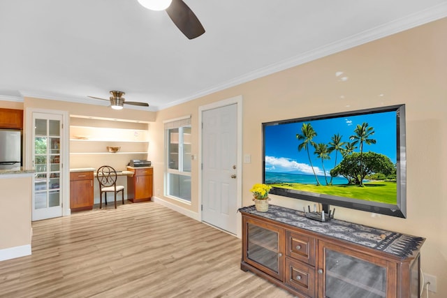 living room with built in shelves, ceiling fan, ornamental molding, and light hardwood / wood-style floors