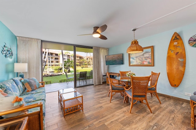 dining space with floor to ceiling windows, wood-type flooring, and ceiling fan