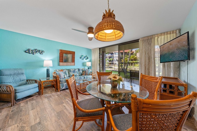 dining area featuring hardwood / wood-style flooring, expansive windows, and ceiling fan