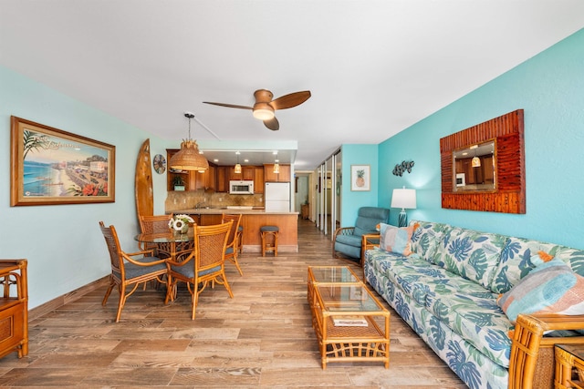 living room featuring light hardwood / wood-style floors and ceiling fan