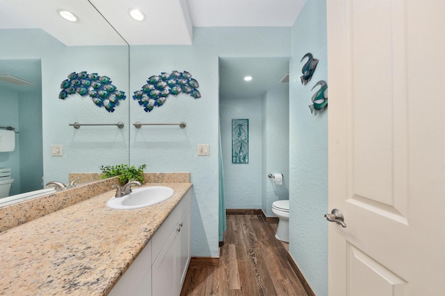 bathroom with wood-type flooring, toilet, and vanity