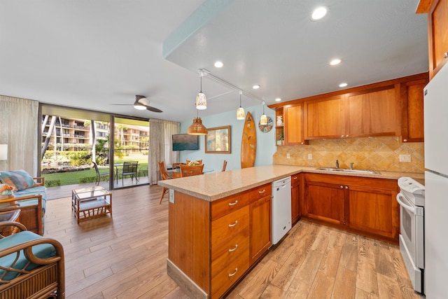 kitchen featuring sink, white appliances, kitchen peninsula, and light hardwood / wood-style floors