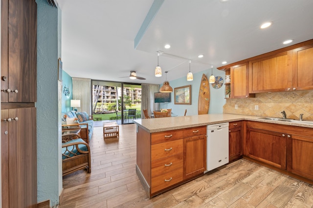 kitchen with dishwasher, light hardwood / wood-style floors, sink, hanging light fixtures, and kitchen peninsula