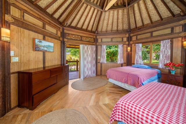 bedroom with high vaulted ceiling, access to exterior, beamed ceiling, and wooden walls