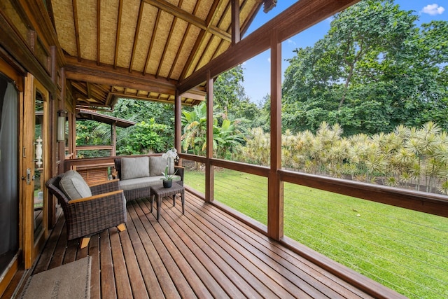 deck with an outdoor living space and a lawn