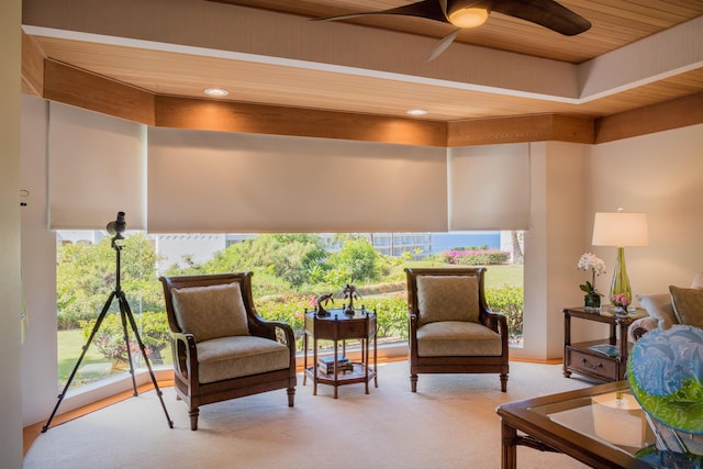 living area with ceiling fan and wooden ceiling