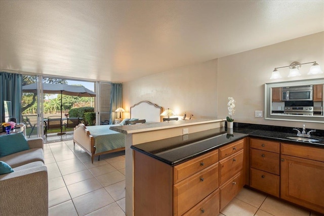 kitchen featuring expansive windows, sink, light tile patterned floors, and kitchen peninsula