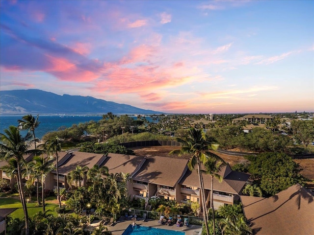 aerial view at dusk featuring a water and mountain view