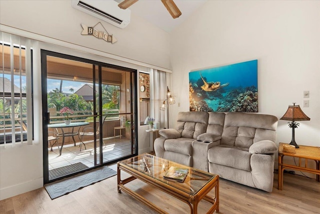 living room with lofted ceiling, wood-type flooring, ceiling fan, and a wall unit AC