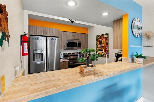 kitchen featuring appliances with stainless steel finishes, kitchen peninsula, and sink