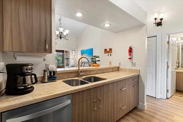 kitchen with decorative light fixtures, dishwasher, a notable chandelier, sink, and light wood-type flooring